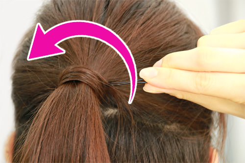 Step2で取り出した髪をゴムの結び目を隠すように髪を巻きつけ、先端をピンで止めます。