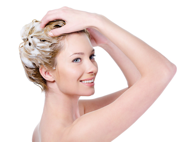 Woman washing hair with shampoo