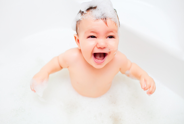 Happy litlle child bathes in a bathroom