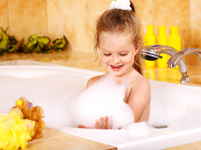 Kid washing in bath.