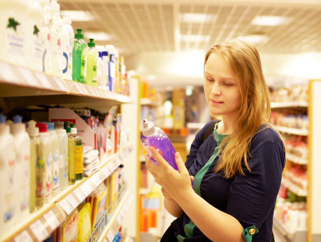 Young woman in the supermarket reading inscription