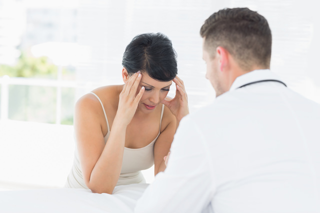 Stressed woman visiting male doctor in clinic