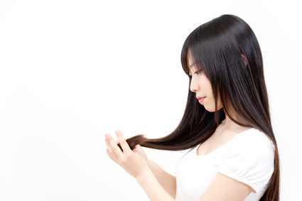 beautiful asian woman taking care of her hair