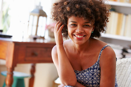 Portrait of a smiling young woman sitting in a room